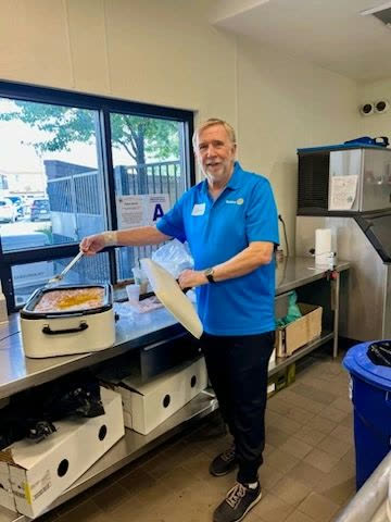 Rotarian serving food from a roaster at the chili cook-off