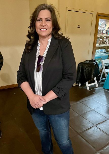 A guest in a black blazer and striped blouse
