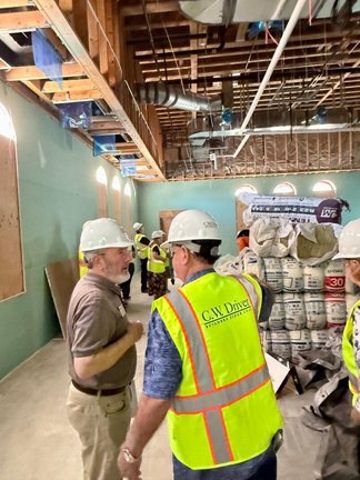 Tour group in hard hats inside the under-construction wing